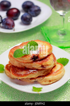 Pile de blinis (à partir de farine blanche, avec prune) garni de sucre en poudre et la menthe sur fond flou Banque D'Images