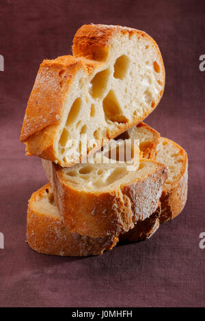 Tranches de pain italien peints en brun sur fond textile Banque D'Images