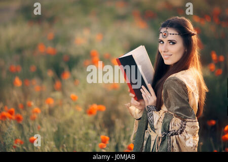 Cité médiévale de la lecture d'un livre magique dans un champ de coquelicots Banque D'Images