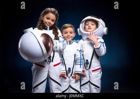 Deux petits garçons et filles dans les combinaisons spatiales des astronautes jouant looking at camera Banque D'Images
