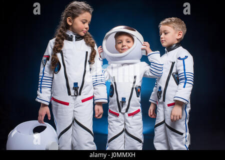 Deux petits garçons et filles dans les combinaisons spatiales des astronautes de jeu Banque D'Images