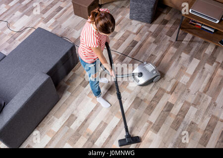 Overhead view of young woman cleaning aspirateur Banque D'Images