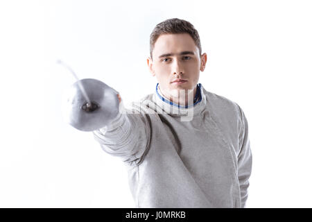 Jeune homme tireur professionnel exerçant à la clôture avec rapière sur blanc Banque D'Images