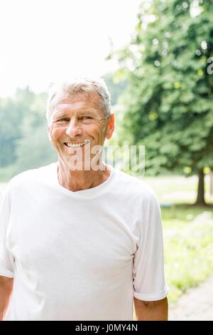 Senior man in white t-shirt smiling, portrait. Banque D'Images