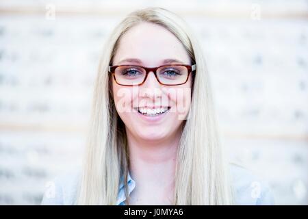 Portrait de femme essayant glasses in optometrist's shop. Banque D'Images
