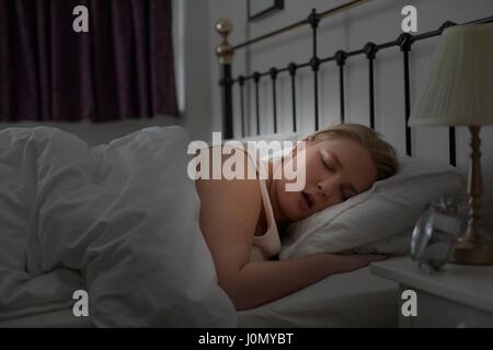 Jeune femme endormie dans le lit. Banque D'Images