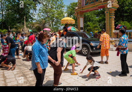 Nakhon Nayok, Thaïlande. 14 avr, 2017. Les enfants se bousculent pour recueillir des rubans bonne chance jeté par les moines lors d'une célébration en 2017 # Songkran, Thaïlande Nakhon Nayok. Credit : Lee Craker/Alamy Live News Banque D'Images