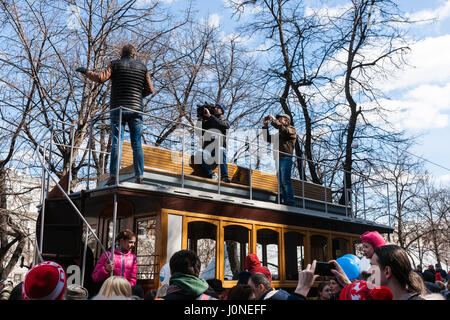 Moscou, Russie. Samedi, 15 avril, 2017. Show Tramway et défilé a lieu à Moscou afin de célébrer 118 ans de rue voiture ville service. Personnes visitent Chistoprudny boulevard (étang) propre à voir et inspecter en personne l'ancien et le nouveau voitures de rues et même et exemple d'un tramway à chevaux vintage. Street car service a été présenté à Moscou en 1899. La rue de Moscou est 417 km (259 ml) de long aujourd'hui. Chaque jour, environ 650 voitures de rues servir 47 itinéraires. Rapports de l'équipe de elevision non identifiés le toit d'une ancienne rue voiture tirée par des chevaux. © Alex's Pictures/Alamy Live News Banque D'Images