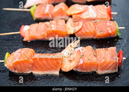 Filets de saumon grillés et de gambas saine restauration rapide cuits sur une plaque chauffante pour la vente au marché de la rue Bordeaux, France Banque D'Images