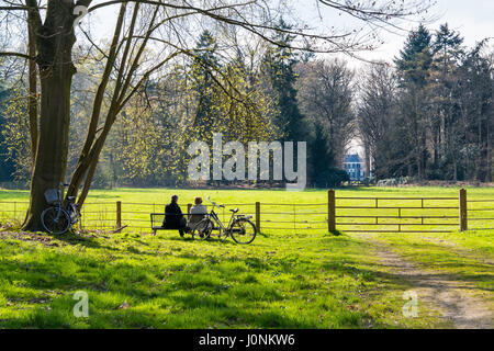 Les gens assis sur un banc après tour en vélo, à la prairie au printemps, plus Boekesteyn country estate, 's Graveland, North-Holland, Pays-Bas Banque D'Images