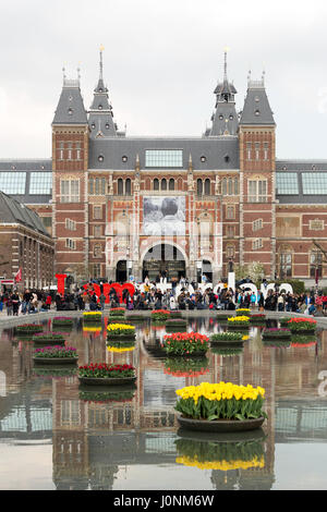 La façade du Rijksmuseum avec le signe et le lac Offres spéciales Iamsterdam avec tulipes flottant devant elle. Banque D'Images