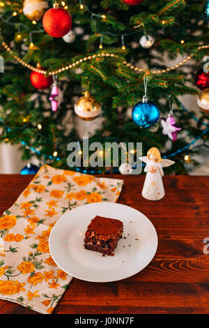 Brownie sur une plaque, sur une texture de bois. Sucré Salé arrosé de caramel. Plusieurs pièces sur une plaque Banque D'Images