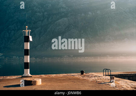 Phare noir et blanc dans la mer. Prcanj, baie de Kotor, Monténégro. Banque D'Images