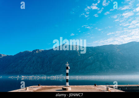 Phare noir et blanc dans la mer. Prcanj, baie de Kotor, Monténégro. Banque D'Images