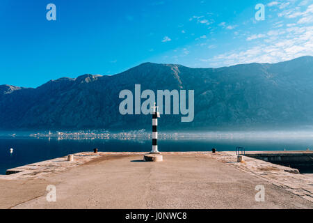 Phare noir et blanc dans la mer. Prcanj, baie de Kotor, Monténégro. Banque D'Images