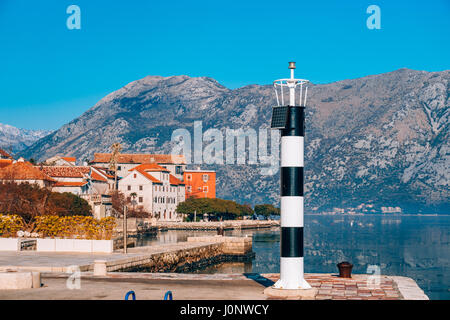 Phare noir et blanc dans la mer. Prcanj, baie de Kotor, Monténégro. Banque D'Images