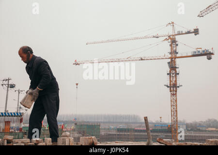 18 Dec 2014,Beijing. un homme sur un site de construction en ville avec des grues et des travailleurs du bâtiment,gare Banque D'Images