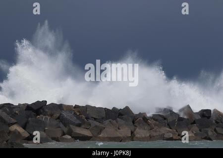 Image de fond d'écume blanche des vagues qui explose dans les blocs de brise-lames dans la plage de Zurriola (San Sebastian, Espagne) 2017. Banque D'Images