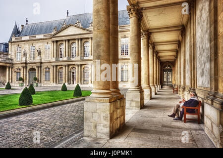 Un homme âgé de la lecture d'un livre en musée des Archives nationales (Musée de l'Histoire de France), l'hôtel de Soubise. Paris. France Banque D'Images