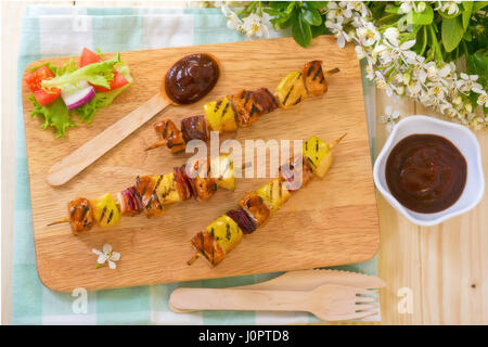 Porc barbecue Brochettes d'oignons et de pommes sur planche de bois Banque D'Images