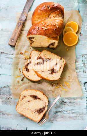 Cozonac gâteau traditionnel roumain avec le cacao et l'orange sur fond bleu Banque D'Images