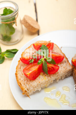 Bruschetta aux tomates italiennes avec le thym et les feuilles de menthe Banque D'Images