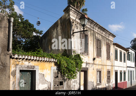 Couler le long des bâtiments en ruine dans une mauvaise partie de Funchal, Madère. Le téléphérique de Monte peut être vu dans l'arrière-plan Banque D'Images