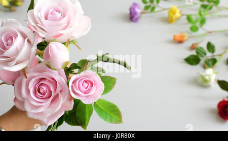 L'argile, l'art merveilleux main femme bouquet de fleurs roses en rose sur fond blanc, de belles fleurs artificielles de l'artisanat habile avec Banque D'Images