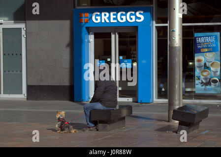 Personne à capuchon isolé avec chien yorkshire emblématique d'Greggs St Enoch Glasgow Banque D'Images