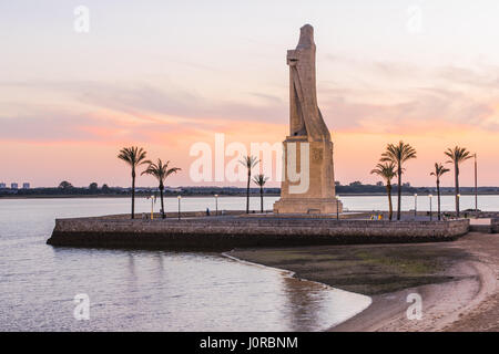 La foi de découverte de Christophe Colomb Monument à Palos de la Frontera, Espagne à blue heure après le coucher du soleil avec des silhouettes de palmiers Banque D'Images