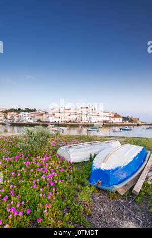 Village de pêcheurs de Ferragudo en Algarve, Portugal avec des bateaux et des fleurs en premier plan Banque D'Images