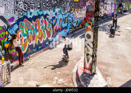 La patineuse adolescent équitation une planche à roulettes dans Leake Street tunnel, Londres, Royaume-Uni. Leake street aussi connu sous le nom de "Tunnel" ou le Graffiti Banksy "tunnel" est une route Banque D'Images