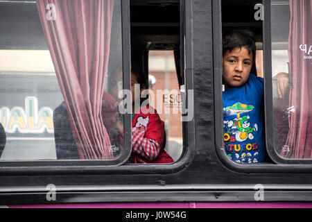 Un petit garçon à la recherche d'un bus, Gualaceo, de l'Équateur. Banque D'Images