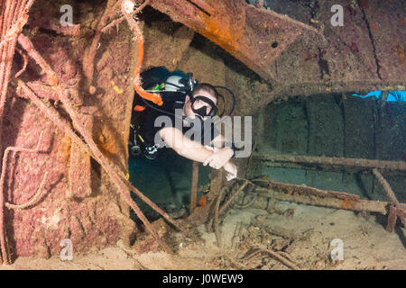 Plongée sous marine natation à travers une vieille épave sous-marine Banque D'Images