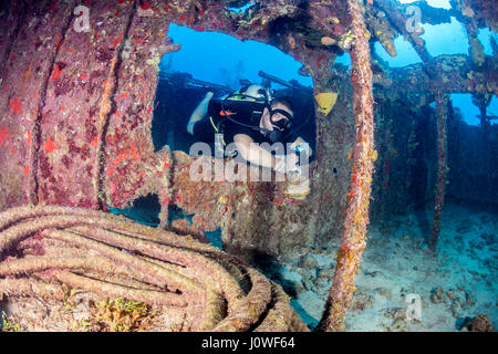 Plongée sous marine natation à travers une vieille épave sous-marine Banque D'Images