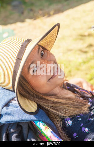 Portrait d'une jolie jeune femme asiatique portant un chapeau de paille et qui regarde la caméra avec un léger sourire. Banque D'Images