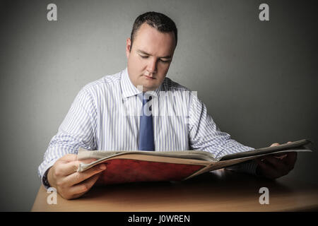 Businessman reading énorme livre Banque D'Images