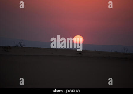 La Jordanie fiery coucher du soleil dans le désert paysage sur la route vers la mer Morte, le lac de sel bordée par la Jordanie à l'Est et d'Israël et de la Palestine à l'ouest Banque D'Images