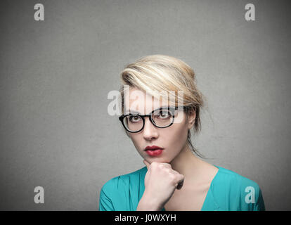 Femme blonde lunettes en pensant Banque D'Images