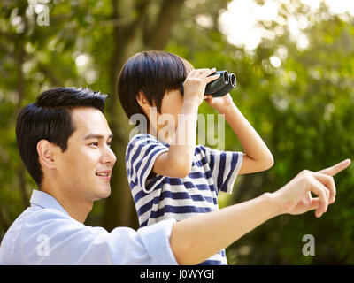 Asian père et fils à l'aide de jumelles dans park Banque D'Images