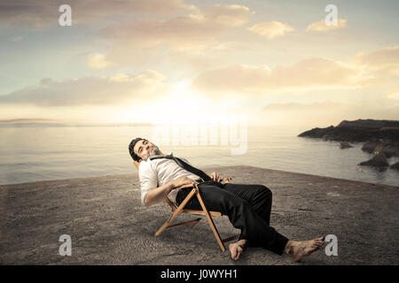 Businessman resting on the beach Banque D'Images