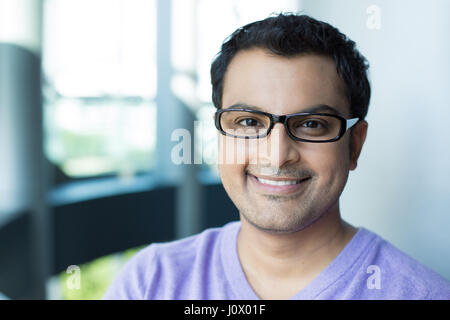 Closeup portrait portrait, smiling happy handsome man dans v-cou pull mauve, le port de lunettes noires, isolé à l'intérieur. Banque D'Images