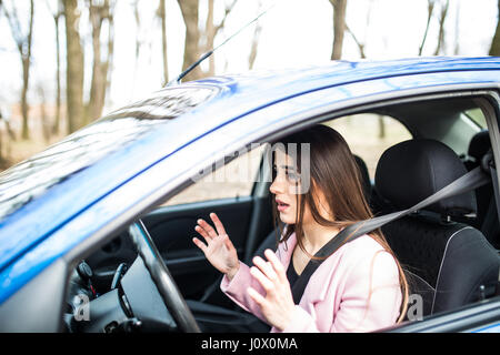 Femme peur choqué avant de planter ou d'accident les mains hors de roue sur route Banque D'Images