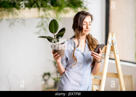 Femme avec téléphone et cache-pot Banque D'Images