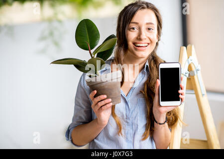 Femme avec téléphone et cache-pot Banque D'Images