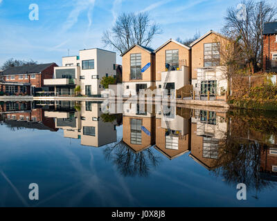 Côté Canal homes reflétée dans le canal Ashton, Audenshaw, Tameside, Manchester, Angleterre, Royaume-Uni. Les trois sur la droite sont appelés 'Le chantier'. Banque D'Images