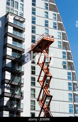 Plate-forme élévatrice à ciseaux (accès) sur le côté de l'un des blocs d'appartements NV, Salford Quays, Manchester, Angleterre, RU Banque D'Images