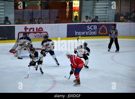 Les joueurs de l'équipe de Malaisie se défendre contre l'objectif de la Mongolie en match de hockey sur glace dans la patinoire alors que la Thaïlande Bangkok montres arbitre Banque D'Images