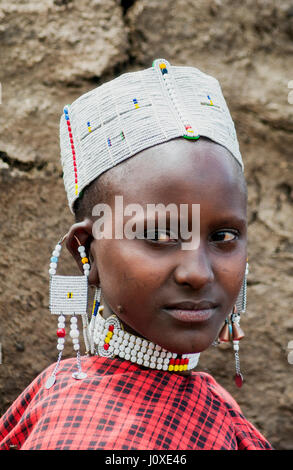 Portrait de jeune femme Massaï en face de la hutte de boue dans des tons ocre Banque D'Images