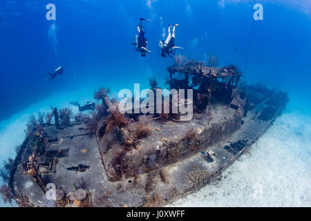 Les plongeurs jouant autour d'un vieux sous-marin incrusté de shipwreck Banque D'Images